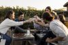 A group of people happily clinking wine glasses